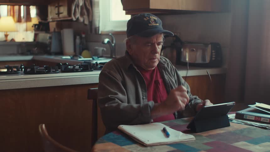 A man uses his tablet and takes notes