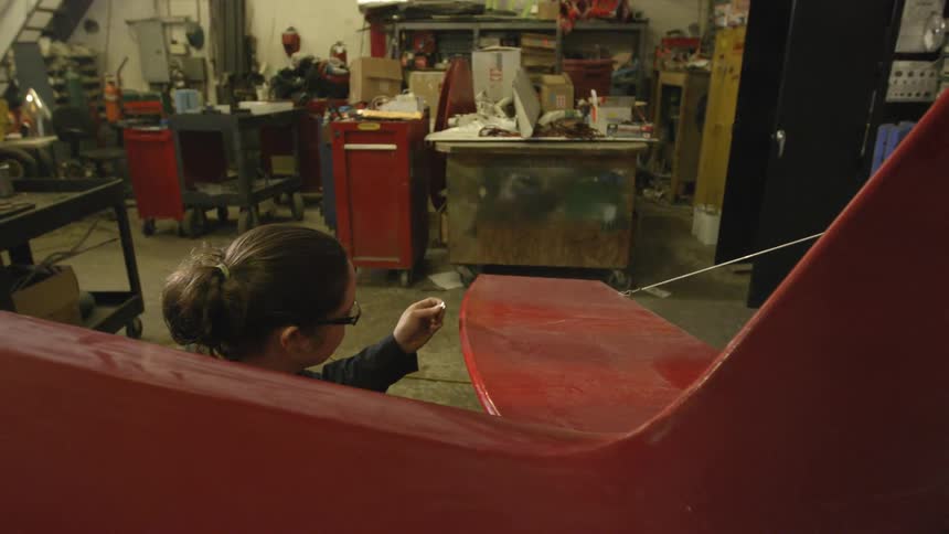 Woman working on a curved  surface in a workshop