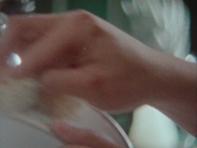 Closeup of a young woman washing a white canister in the kitchen