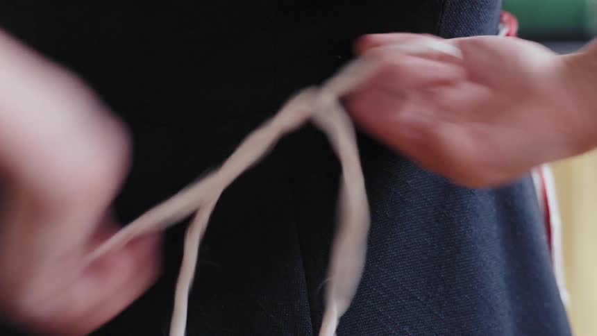 Hands of a woman untying an apron