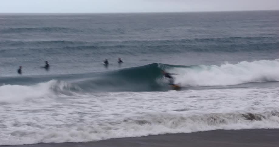Surfer doing a radical maneuver on a wave at the beach