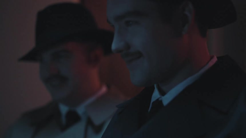 Two mustached men wearing hat in long coat looking with smile