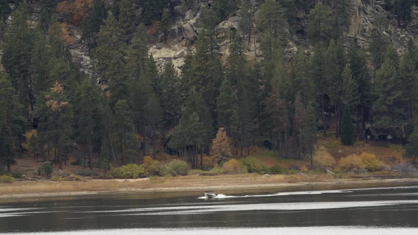 A boat is gliding across the lake in the mountains