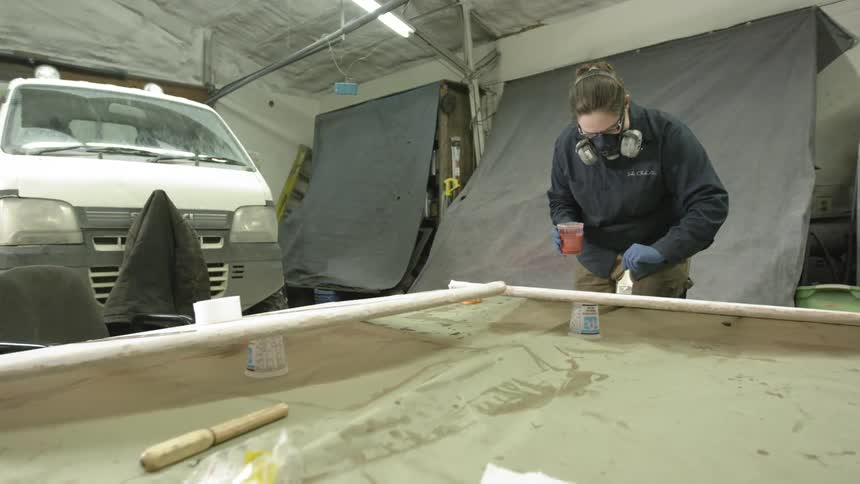 Man wearing a mask while painting a stick