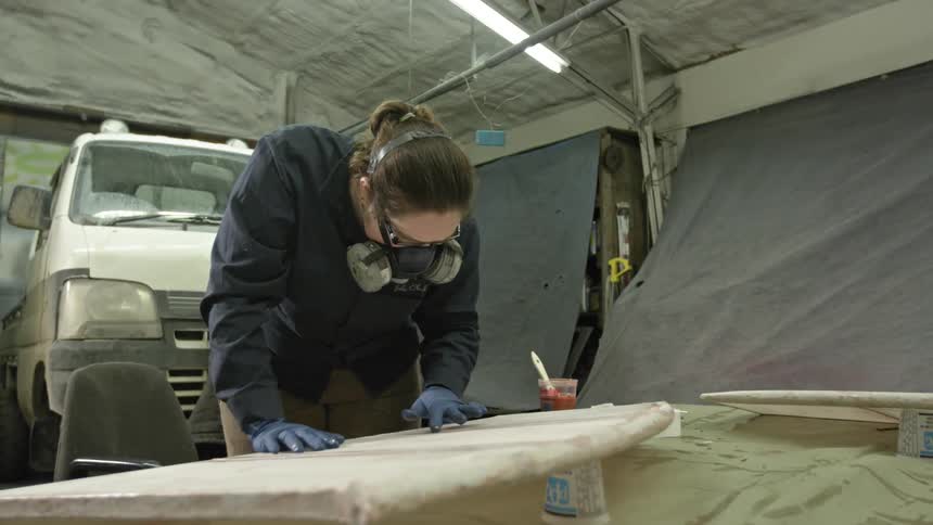 A woman works with a face mask in a garage