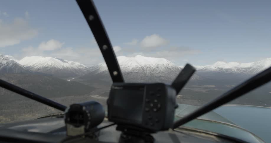 Snow-covered  mountains in the distance as seen from a flying prop plane