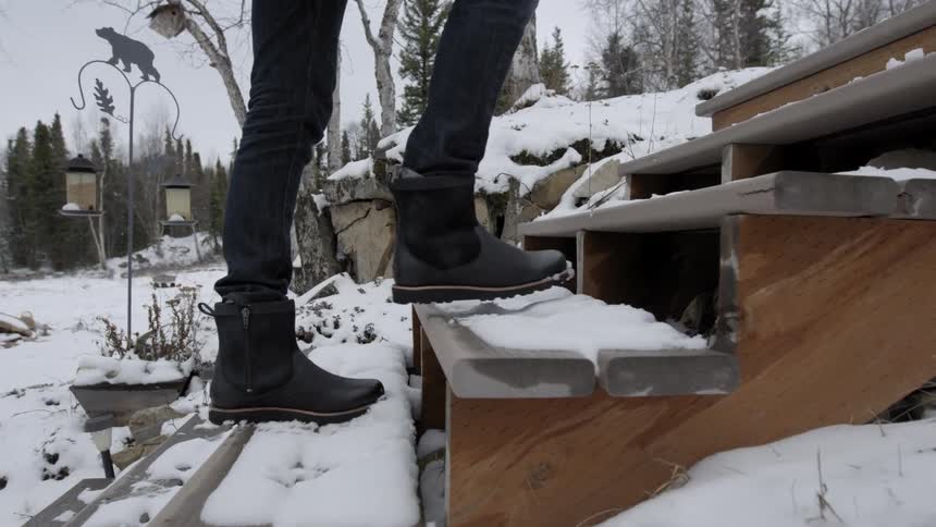 Person walking up snow-covered wooden steps