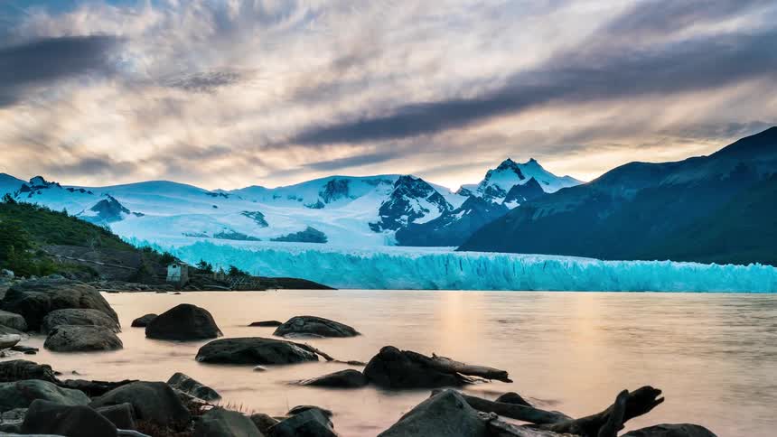 A view of the perito moreno glacier in patagonia with its towering ice wall reflecting the dramatic sunset sky