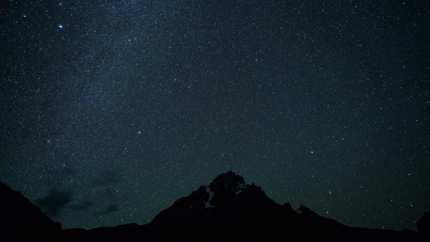 Starry night sky with a mountain silhouette in the background