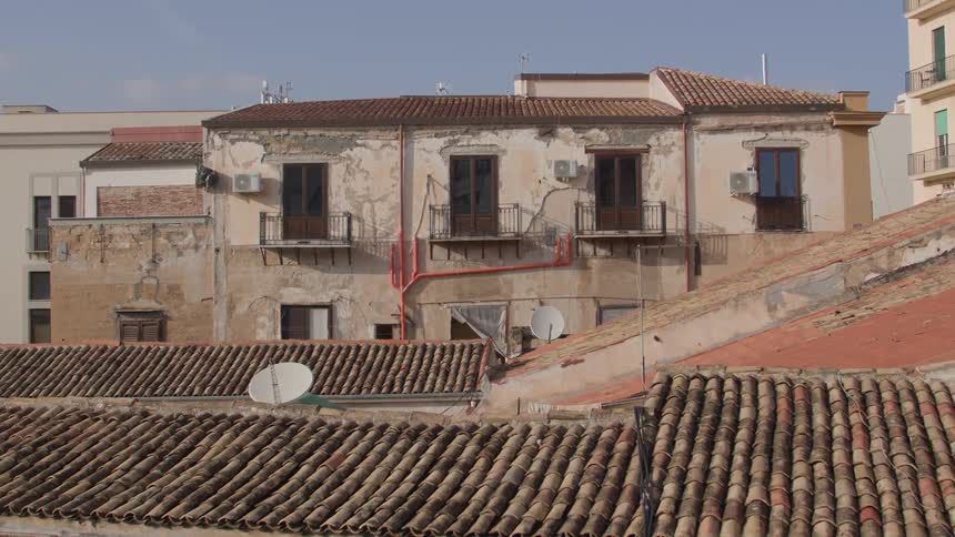 Radar dishes dot the roof of a series of suburban buildings