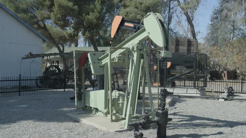A replica of an oil drilling rig surrounded by a fence