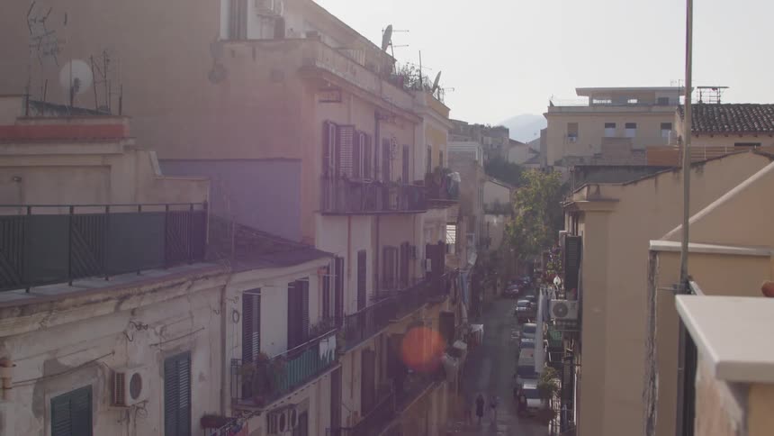 Person rides a moped through the narrow alley between roadhouses
