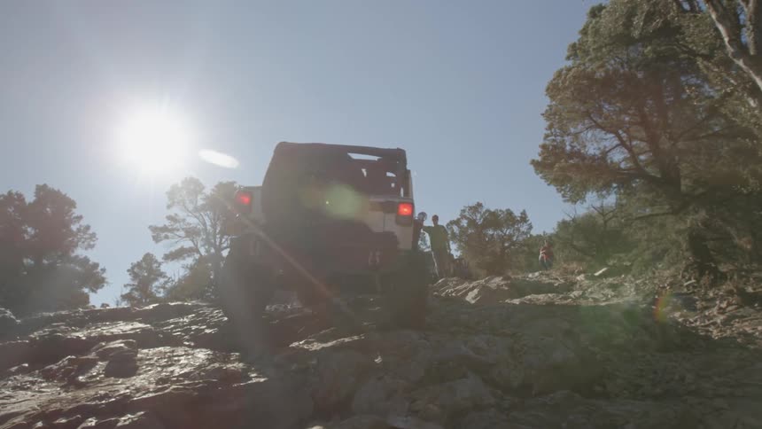A jeep climbs a steep rocky trail