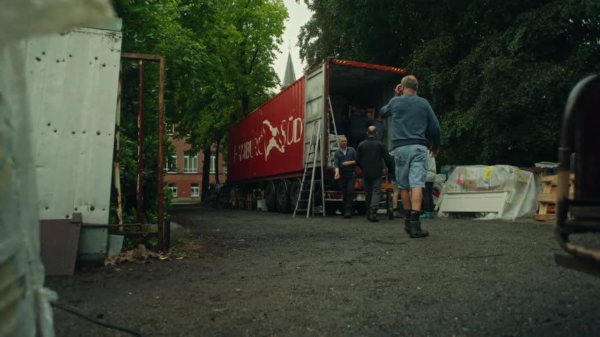 Men are unpacking the truck in the lot