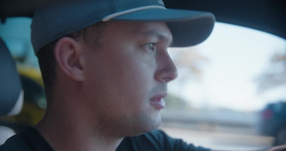 A man speaks while driving a car on an interstate