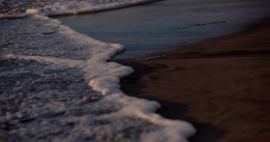Tide gently rolling onto the shoreline at sunrise