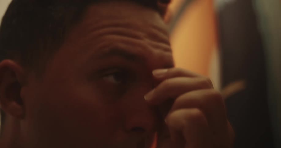 Man looking at himself in the mirror and doing his eyebrows