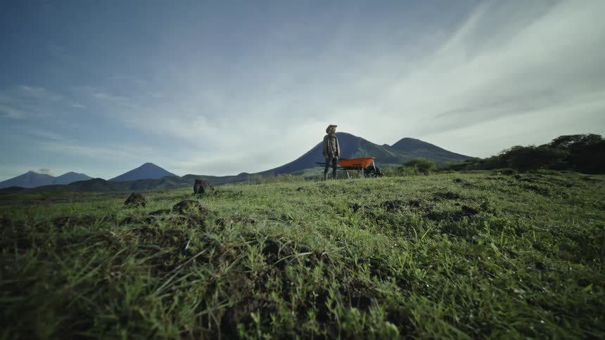 Man in hat on a hill on a partly cloudy day
