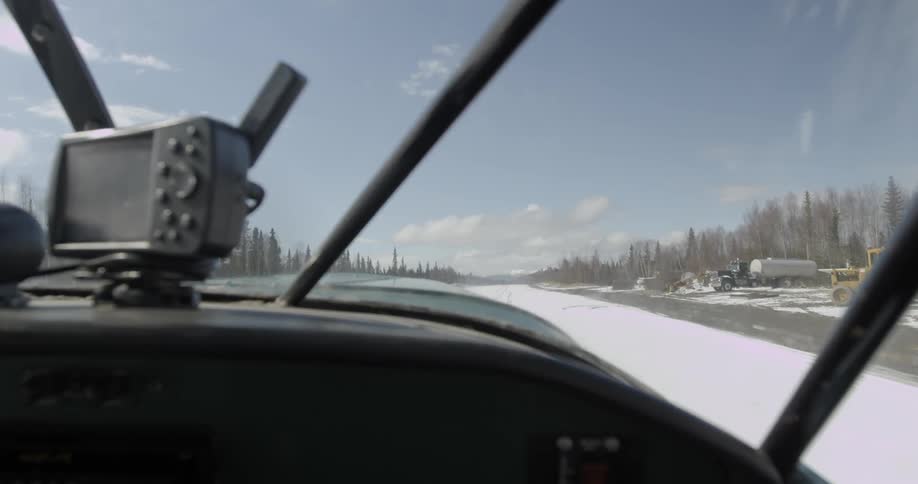 Snow-covered runway as seen from inside a taxiing prop plane