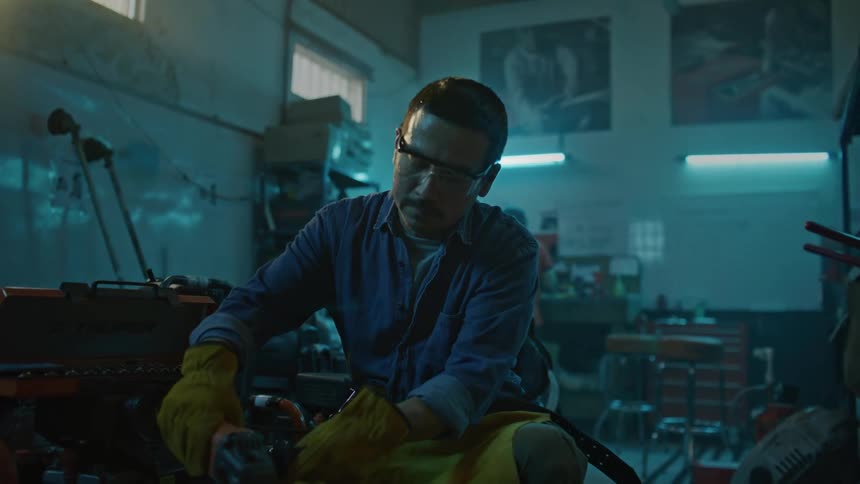 Man with gloves and protective glasses working in a workshop