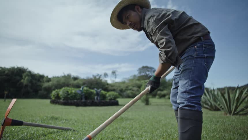 An employee rakes a carefully maintained lawn