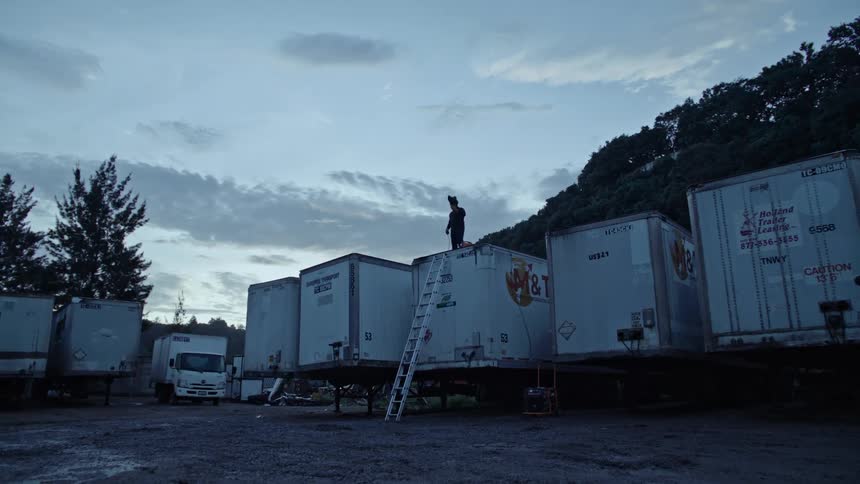 Person on top of a parked cargo truck
