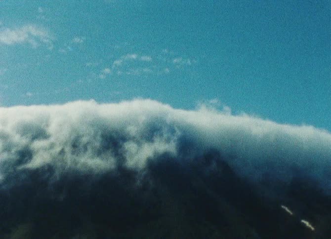 A large cloud bank floats high in a blue sky