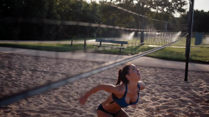 Woman jumping on an openair sand volleyball court