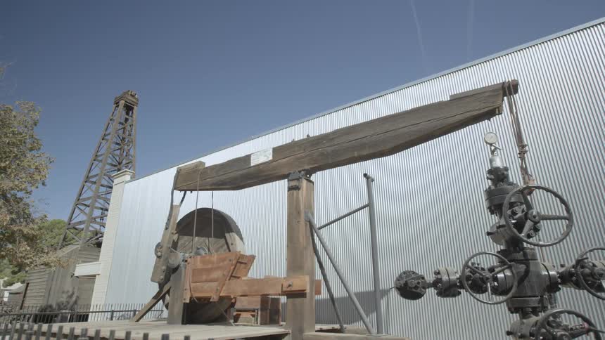 The arm of a piece of equipment rocks back and forth turning a wheel