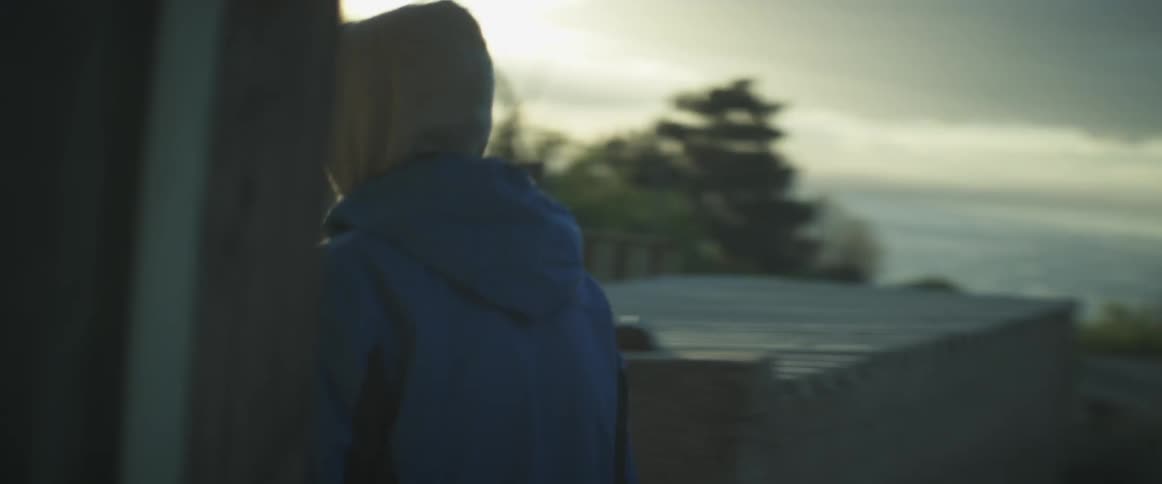 Man walks past a horse towards another man at sunset