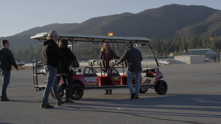 People get on a cart transport on the runway