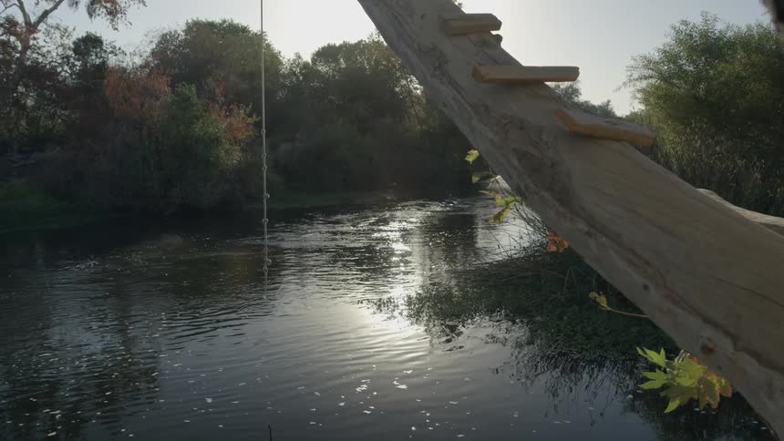 Rope hanging from a man-made ladder lakeside