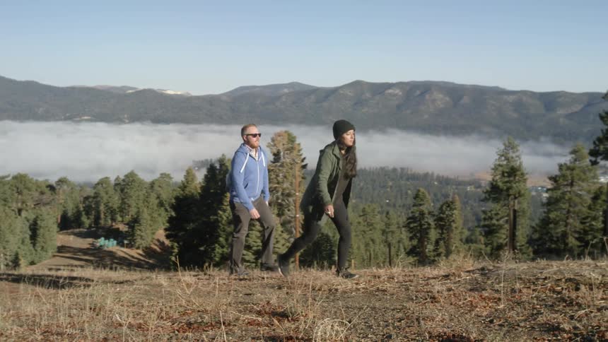 Couple  walking  up a small incline in the wilderness