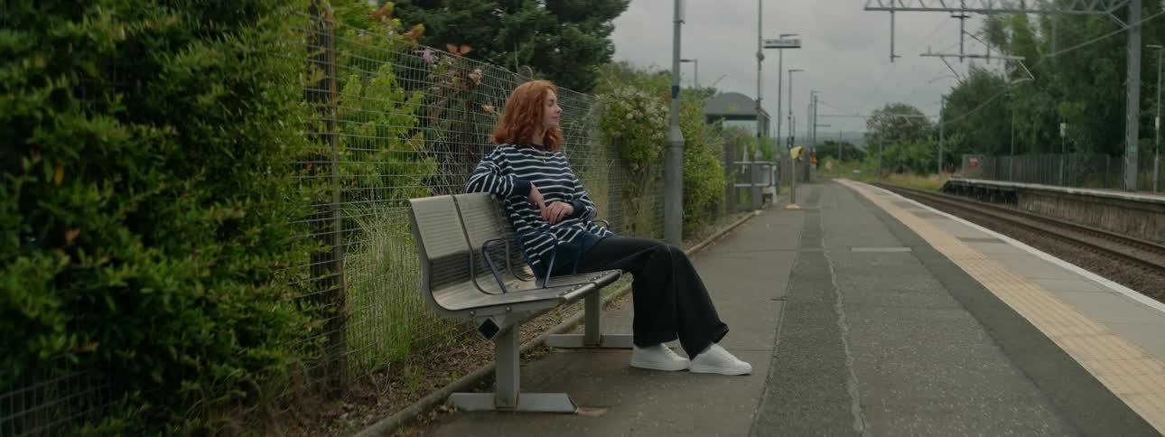 Woman sitting on a bench in an open subway station