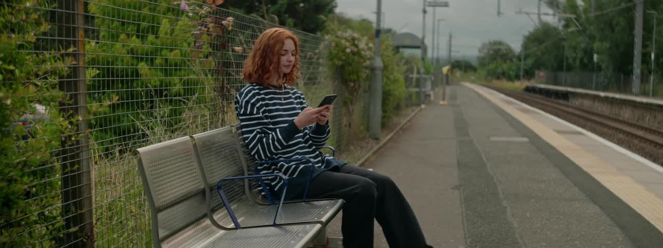 A clip of a lady sitting on a bench