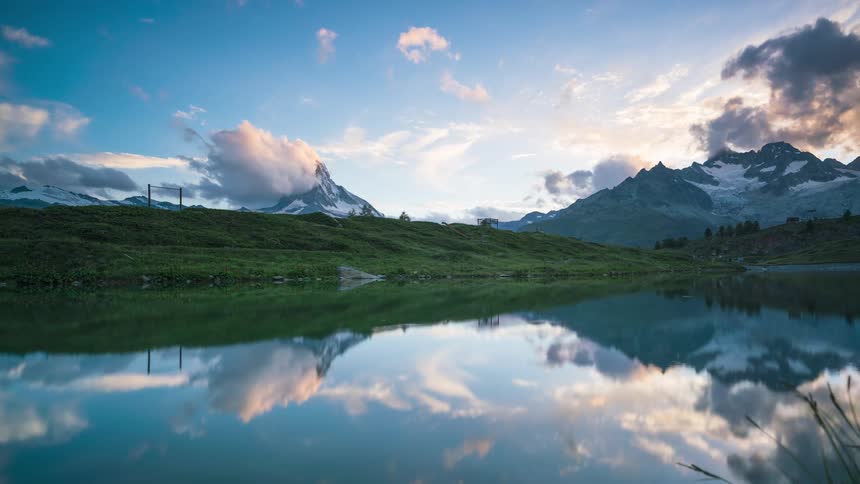 Natural landscape of a lake reflecting snowy mountains on the horizon
