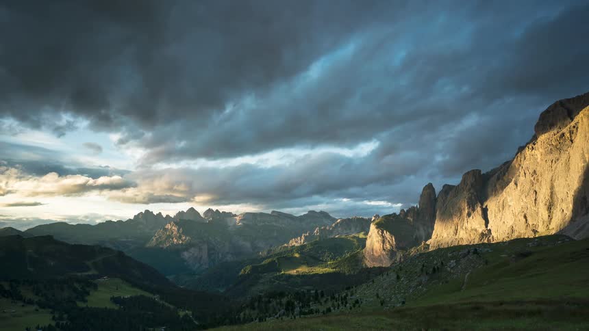 Dark clouds passing overhead in mountainous terrain cast shadows