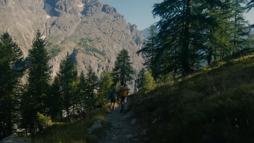People walking on a mountain trail during the day