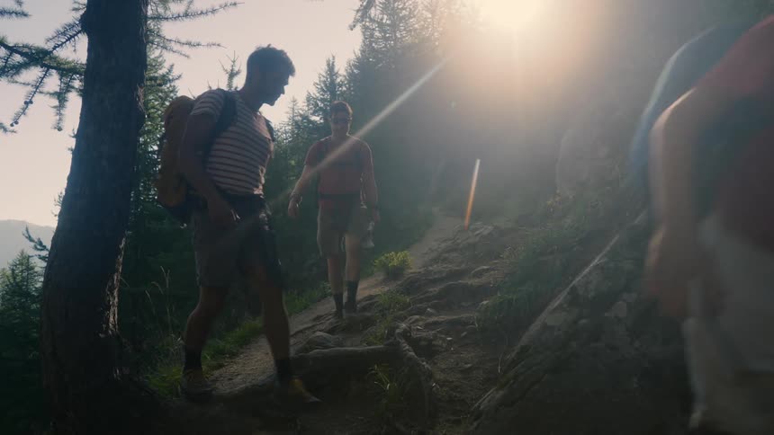 Group of adults and children walking along a mountain trail