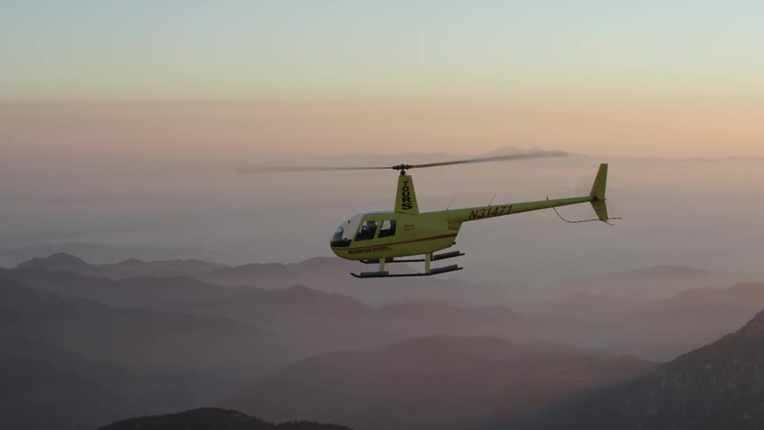 Helicopter flying over hilly landscape