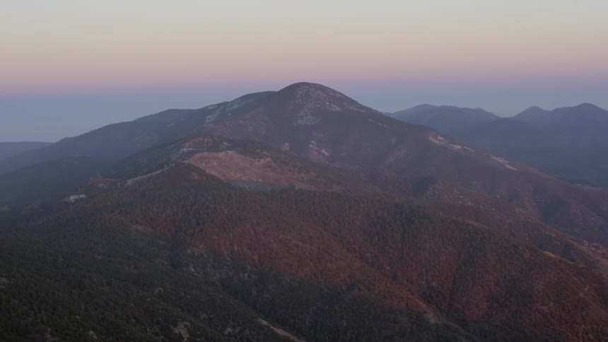A mountain in the distance being filmed from the air