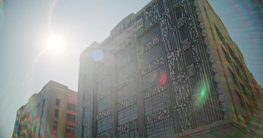 Sun glares down onto a building with an elaborately decorated facade