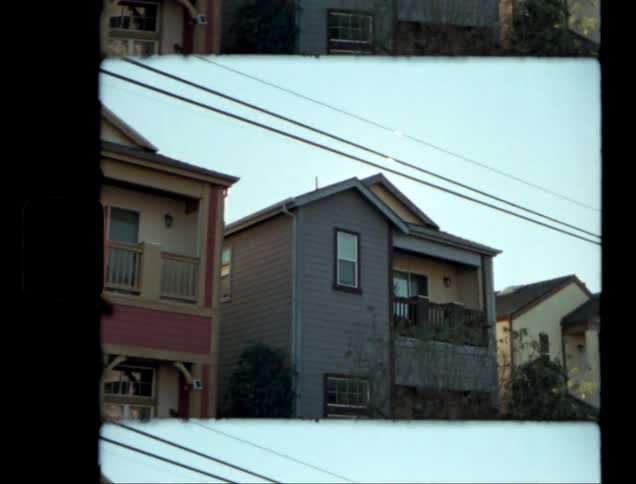 The sun shines brightly over twostory houses with power lines overhead