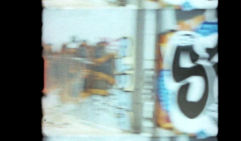 A graffiticovered wall is visible through a fence