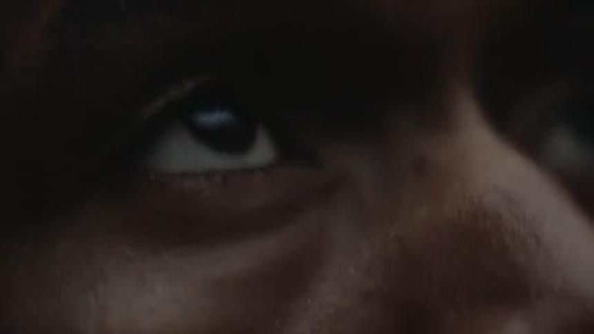 A man closes his eyes as light flashes on his face