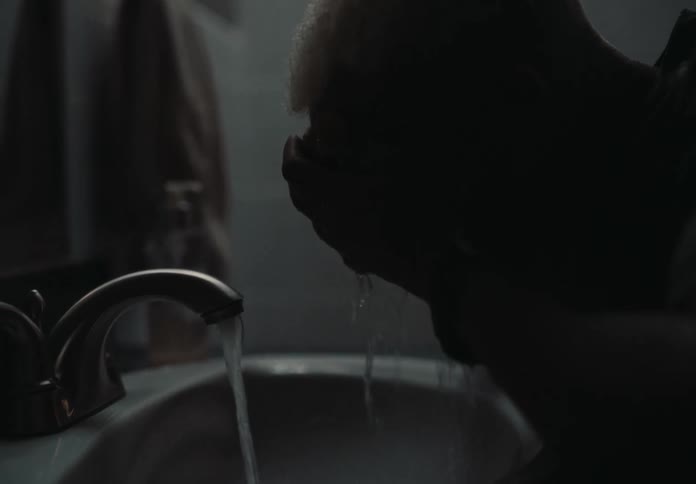 Man washing his face in the bathroom sink