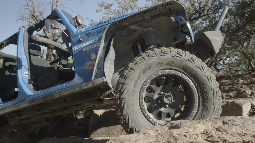 An off-road vehicle struggling to ascend rocky terrain