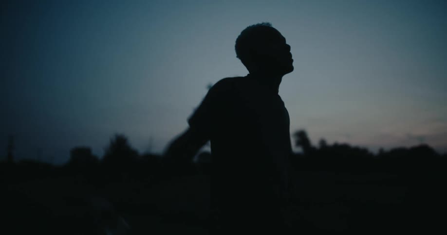 Silhouette of a man warming himself on a dark morning