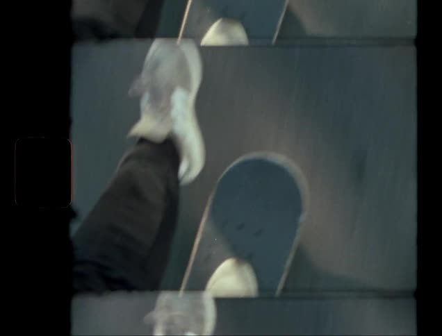 A closeup of a persons feet on a skateboard gliding down a street