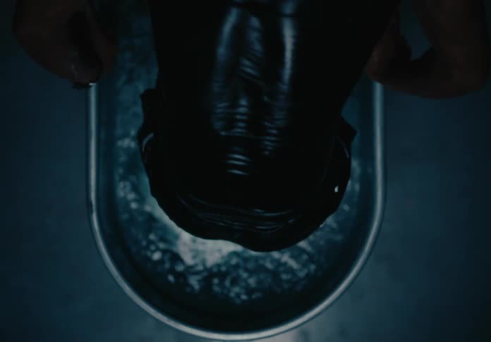 A man emerges from an ice bath in a metal tub